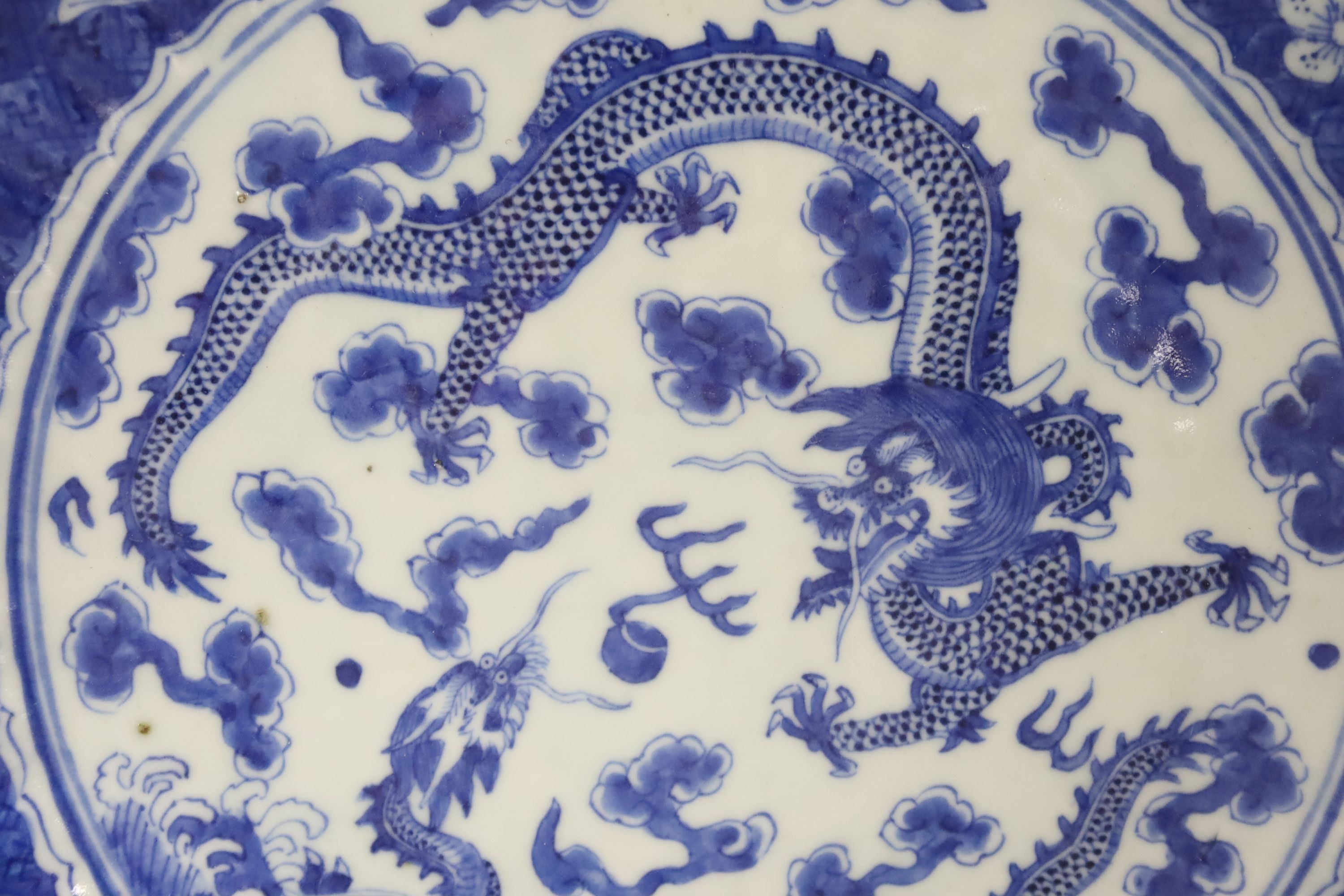 A Chinese blue and white dragon dish, 19th century with a Chenghua mark, 29cm